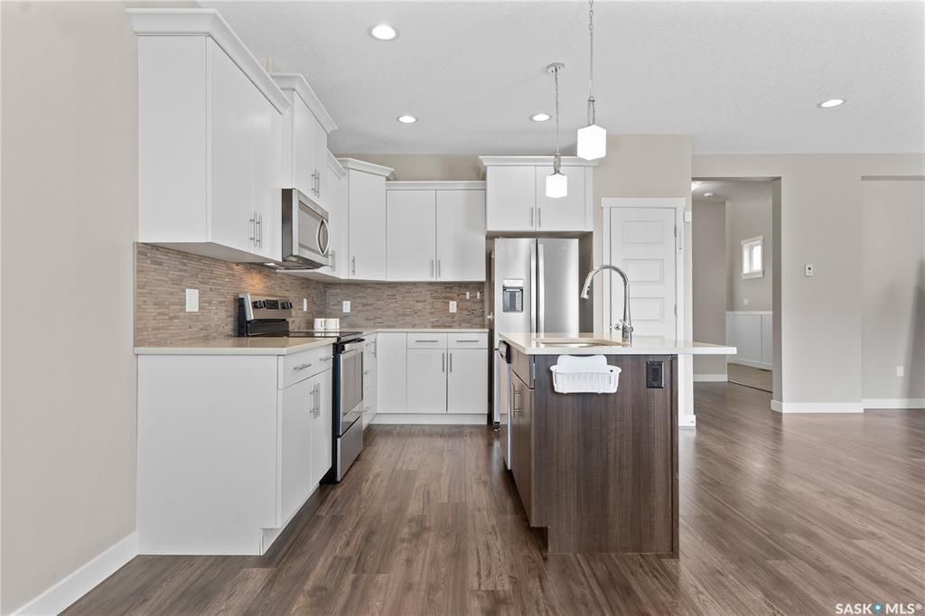 Warman临近高尔夫球场，2017年建1776尺3室3卫联排别墅出售。9ft挑高天花板，房屋保养好。一楼开放式设计，有一个壁炉，厨房带枫木带阻尼橱柜，石英石台面。二楼三间大面积房间，三个浴室和洗衣房。超大主卧带卫生间，装有多功能洗浴设备，双洗手台和步入式衣柜。地下室未装修，带大 - 9